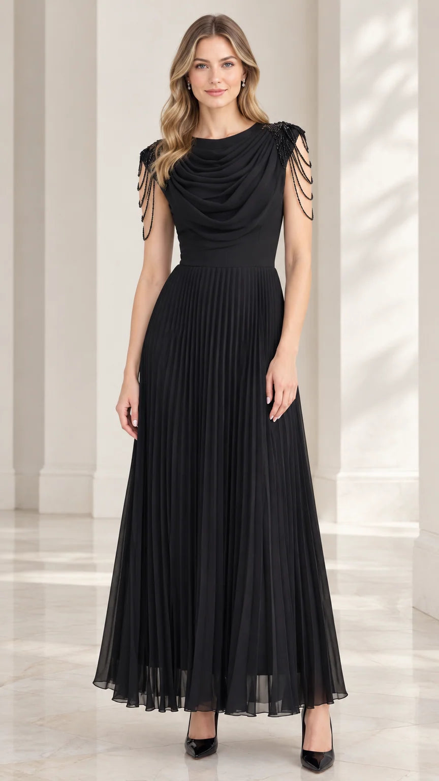 Front view of model wearing black cowl neck pleated maxi evening dress with beaded shoulder fringe