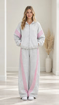 Front view of woman wearing Heather Grey two-piece tracksuit set with pink stripes