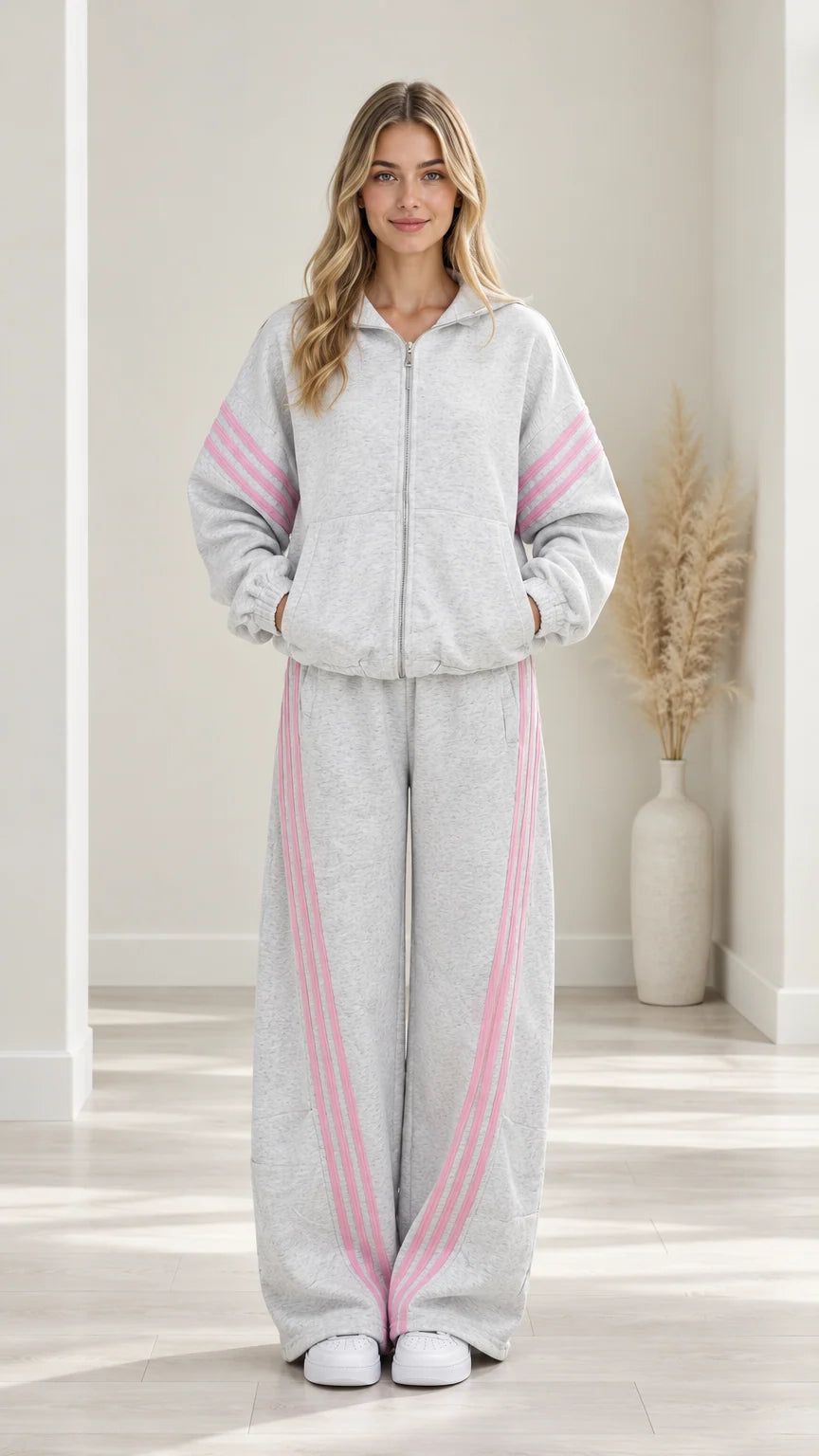 Front view of woman wearing Heather Grey two-piece tracksuit set with pink stripes