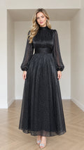 Front full-length view of woman wearing Black sparkle dot mock neck long sleeve maxi dress