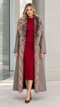 Front full view of woman wearing taupe maxi coat with faux fur collar over a red dress