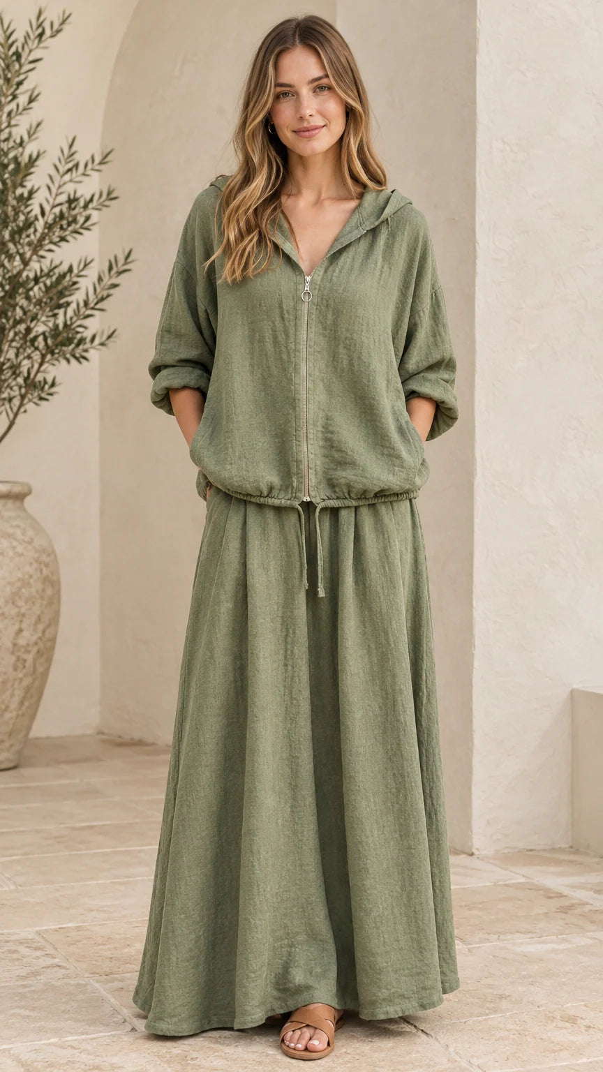 Front view of woman wearing sage green hooded zip-up top and matching maxi skirt set