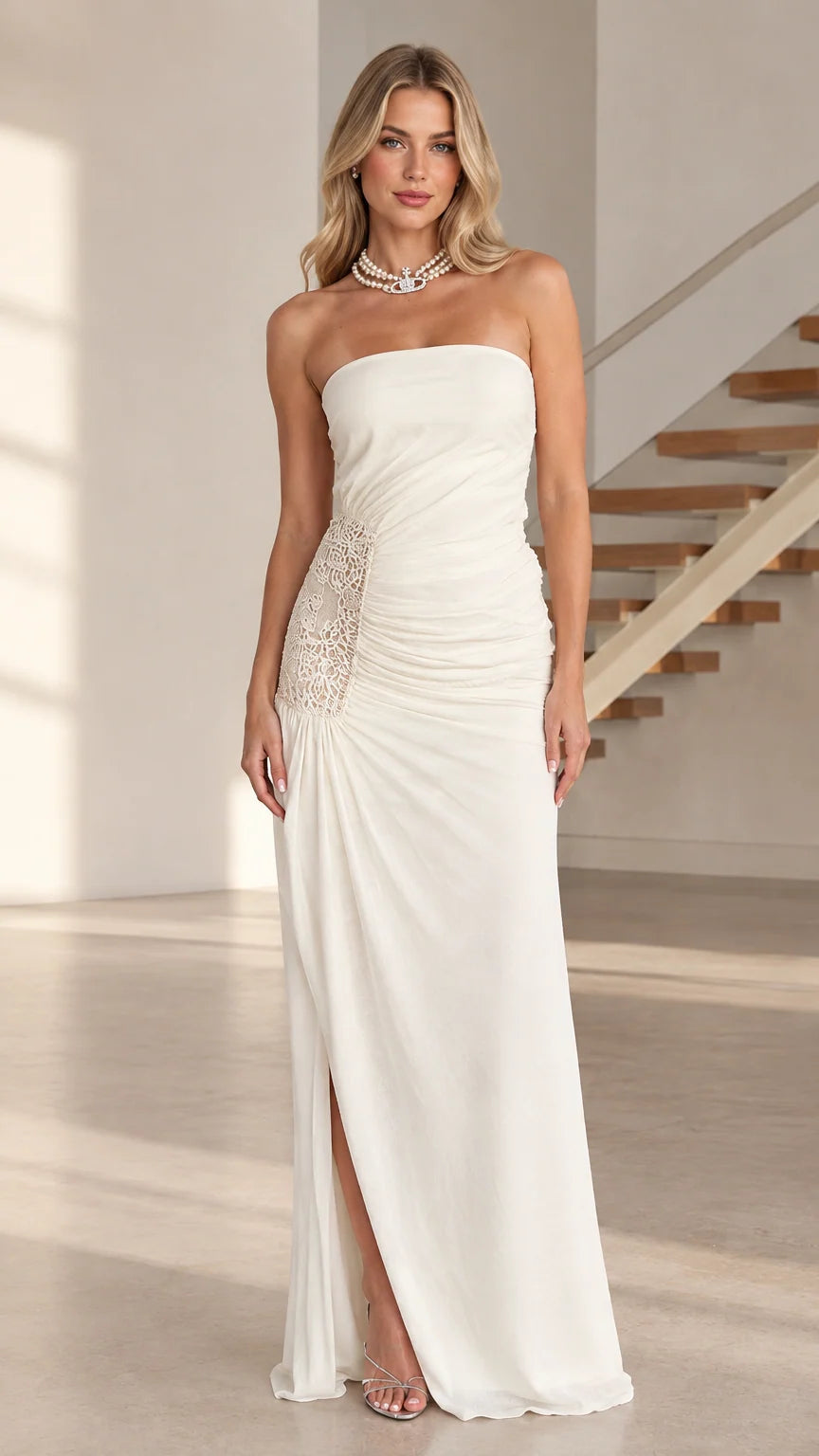 Model wearing white strapless ruched maxi dress with lace side panel and slit - front view