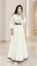 Front full view of white pleated maxi dress with black contrast trim and sheer lantern sleeves