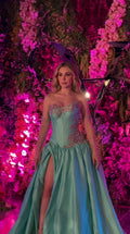 Front view of woman wearing turquoise strapless corset evening gown with high slit and embroidery