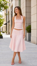 Model wearing the pink halter top and midi skirt set, front view
