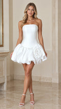 Front full-length view of model wearing white strapless corset bubble mini dress with rosette detail