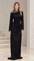 Front full-length view of black rhinestone embellished ruched long sleeve evening maxi gown