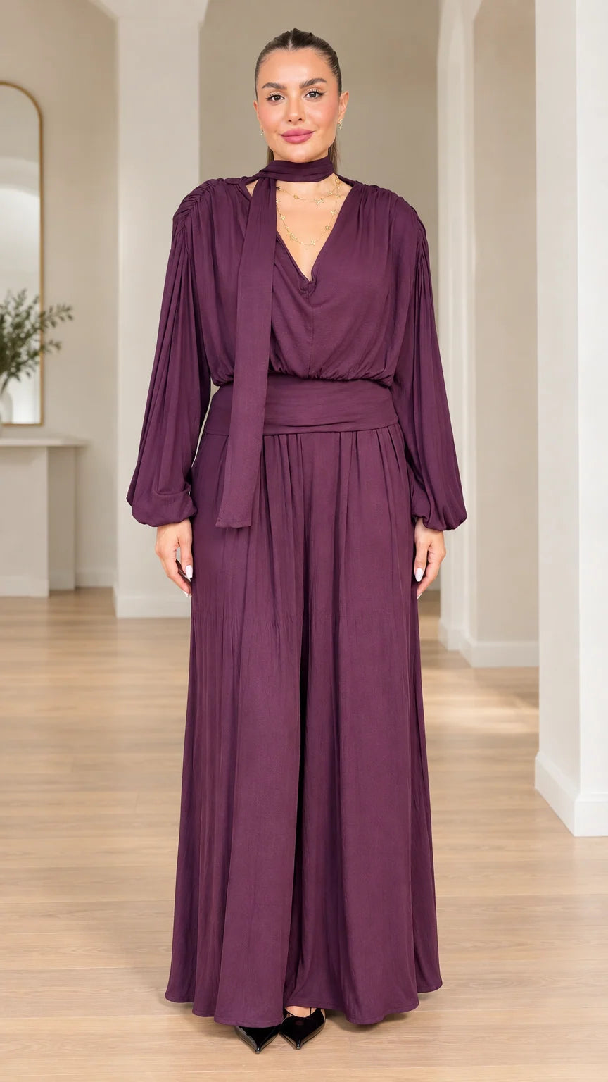 Model wearing plum long-sleeve scarf neck wide-leg jumpsuit front view