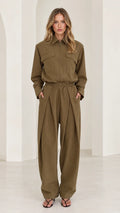 Front full-length view of woman wearing olive green long sleeve pleated wide-leg utility jumpsuit