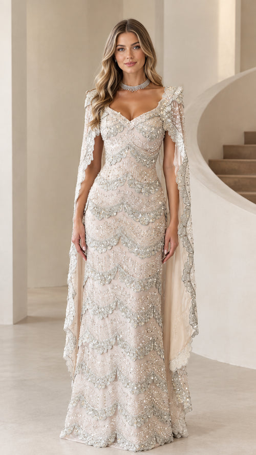 Full-length front view of model wearing champagne beaded scalloped evening gown with matching cape