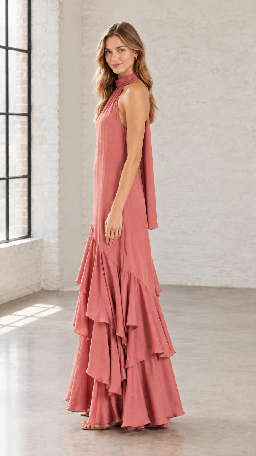 Side angle view of woman in Dusty Rose flowing halter maxi gown