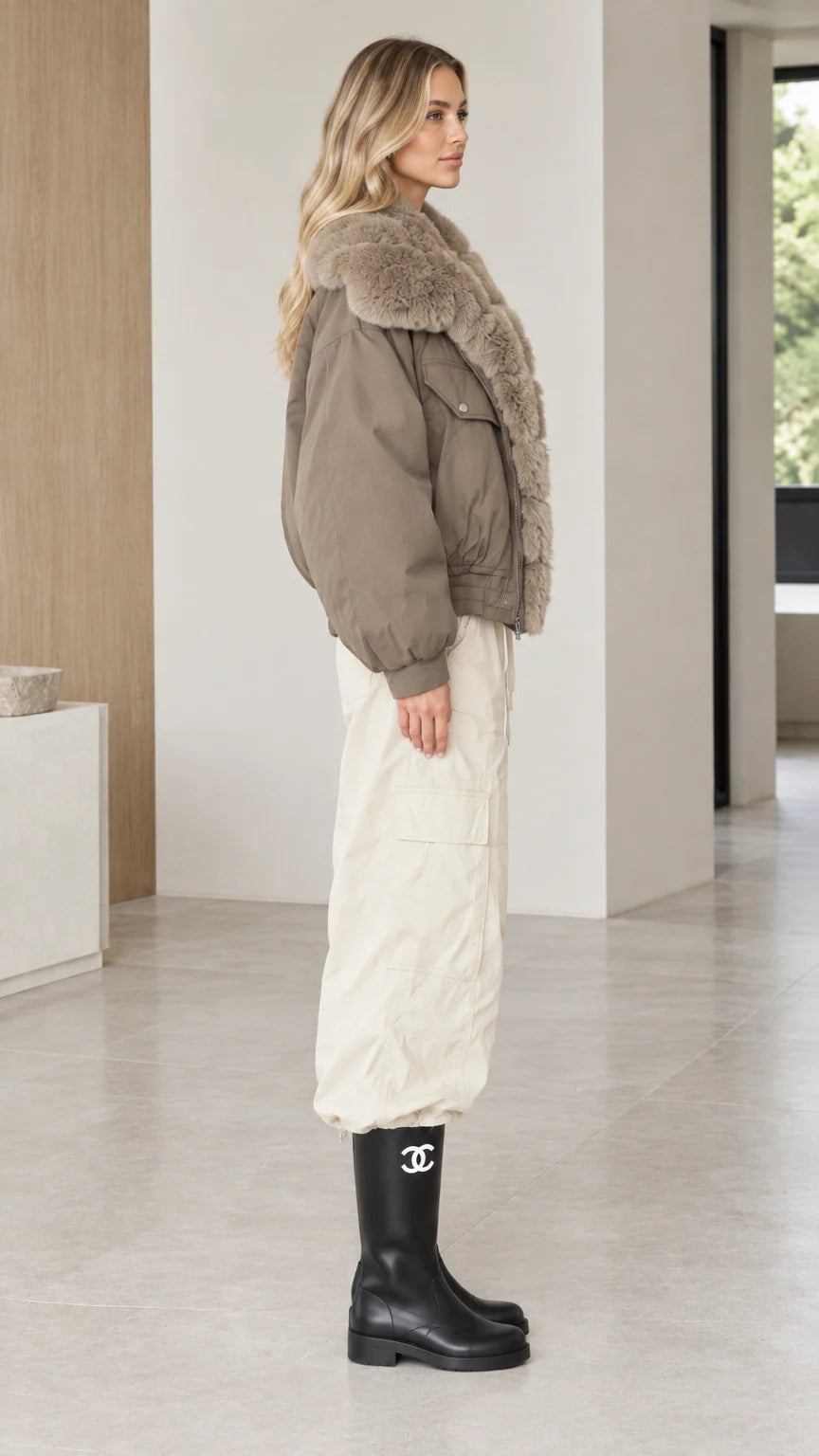 Side view of model styled in taupe bomber jacket with plush fur trim