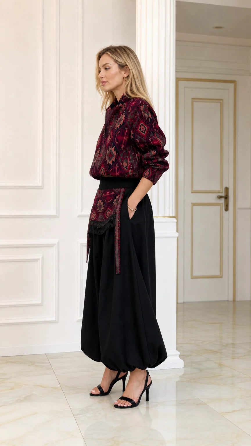Side profile view of burgundy printed top and draped black harem pants set