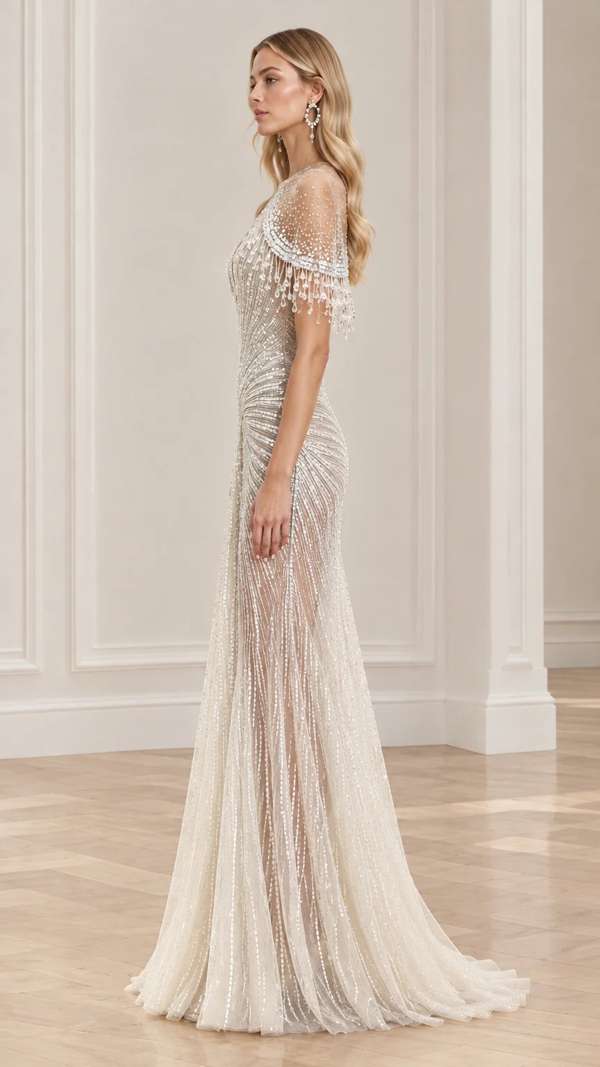 Side profile of floor-length ivory beaded evening gown showing sheer capelet sleeve