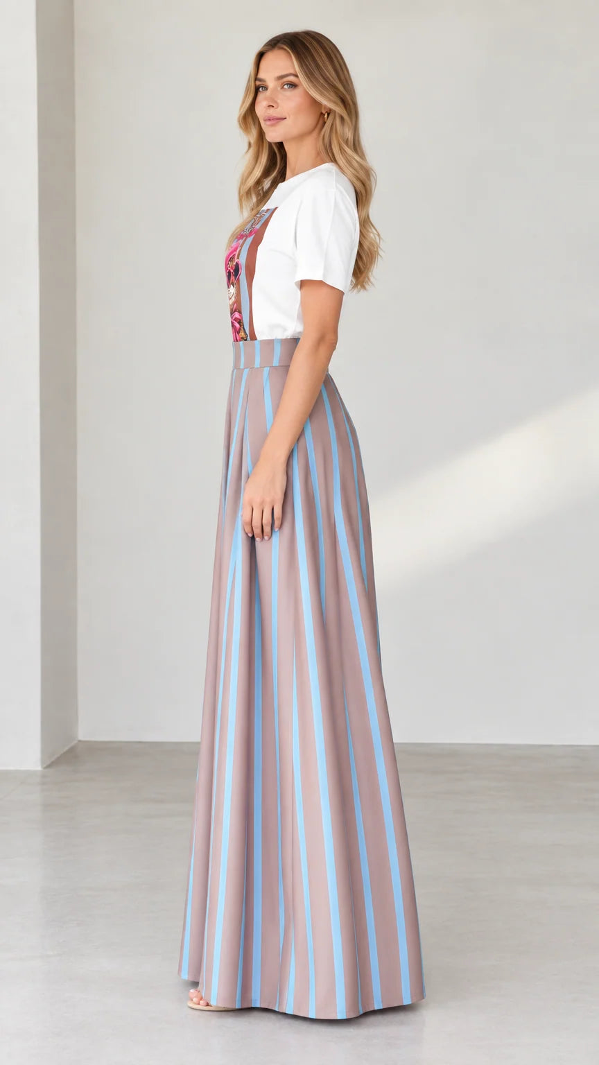 Side profile of woman in graphic t-shirt and pleated striped palazzo pants in mocha