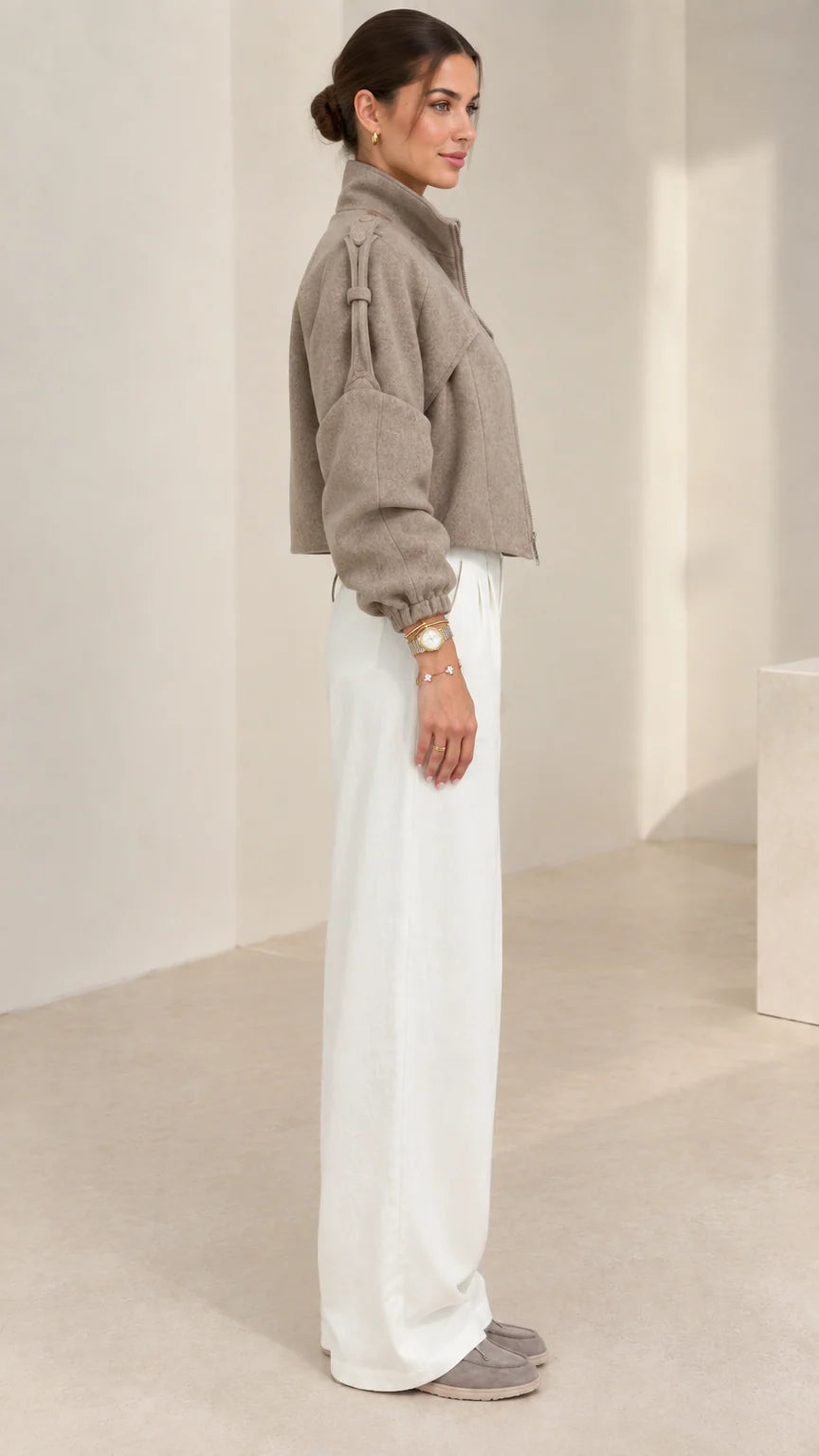 Side profile view of taupe cropped short jacket showing sleeve volume and fit