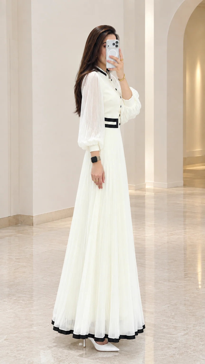 Side profile view of white long sleeve pleated maxi evening dress