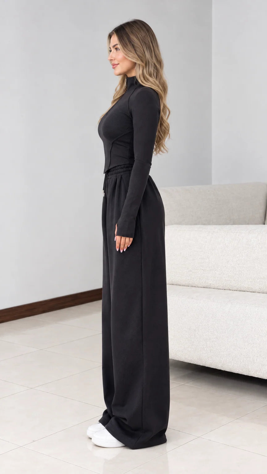 Side view of model wearing black two-piece wide leg tracksuit