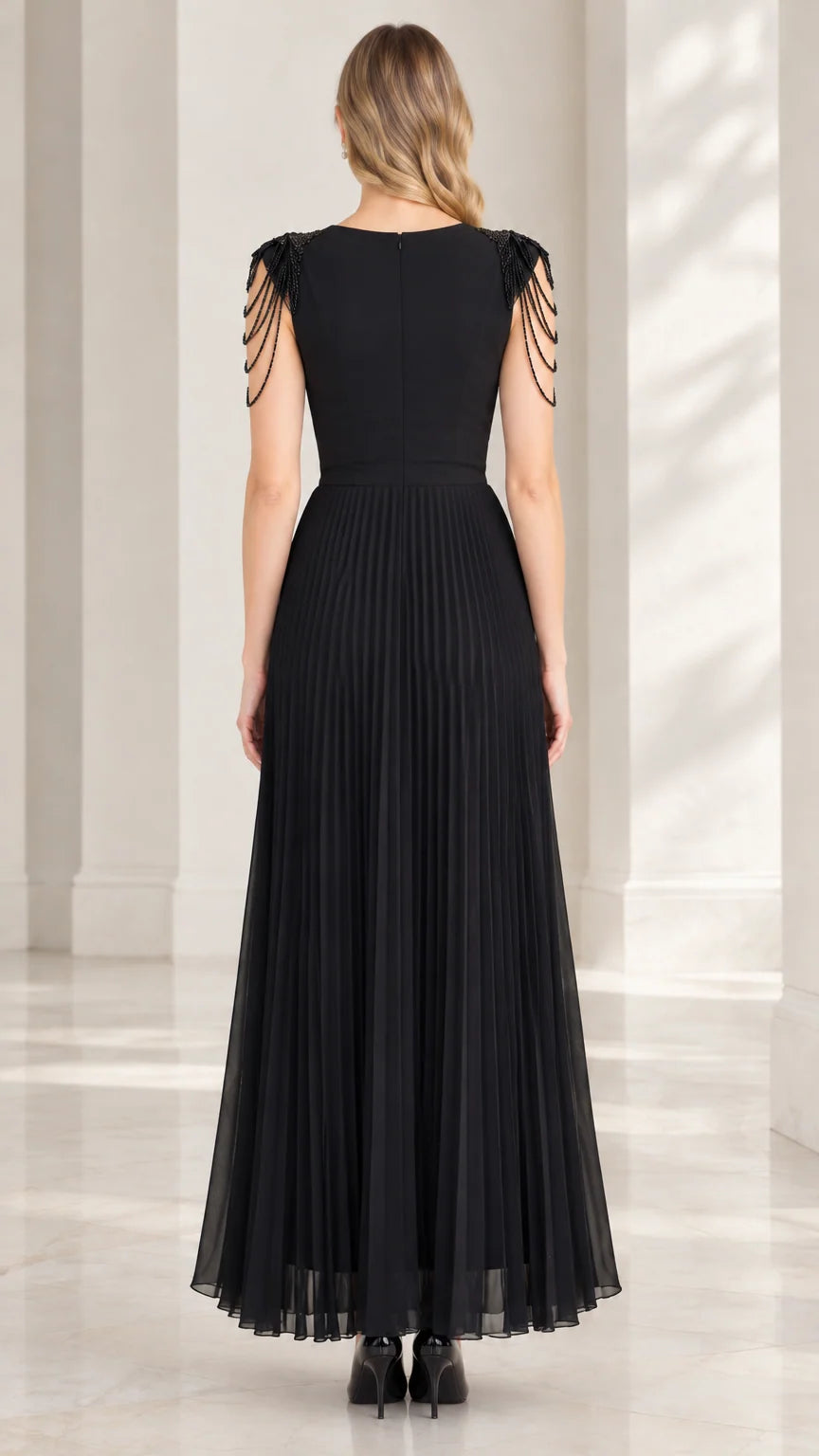 Back view of black floor-length formal dress showing sleek back and pleated skirt