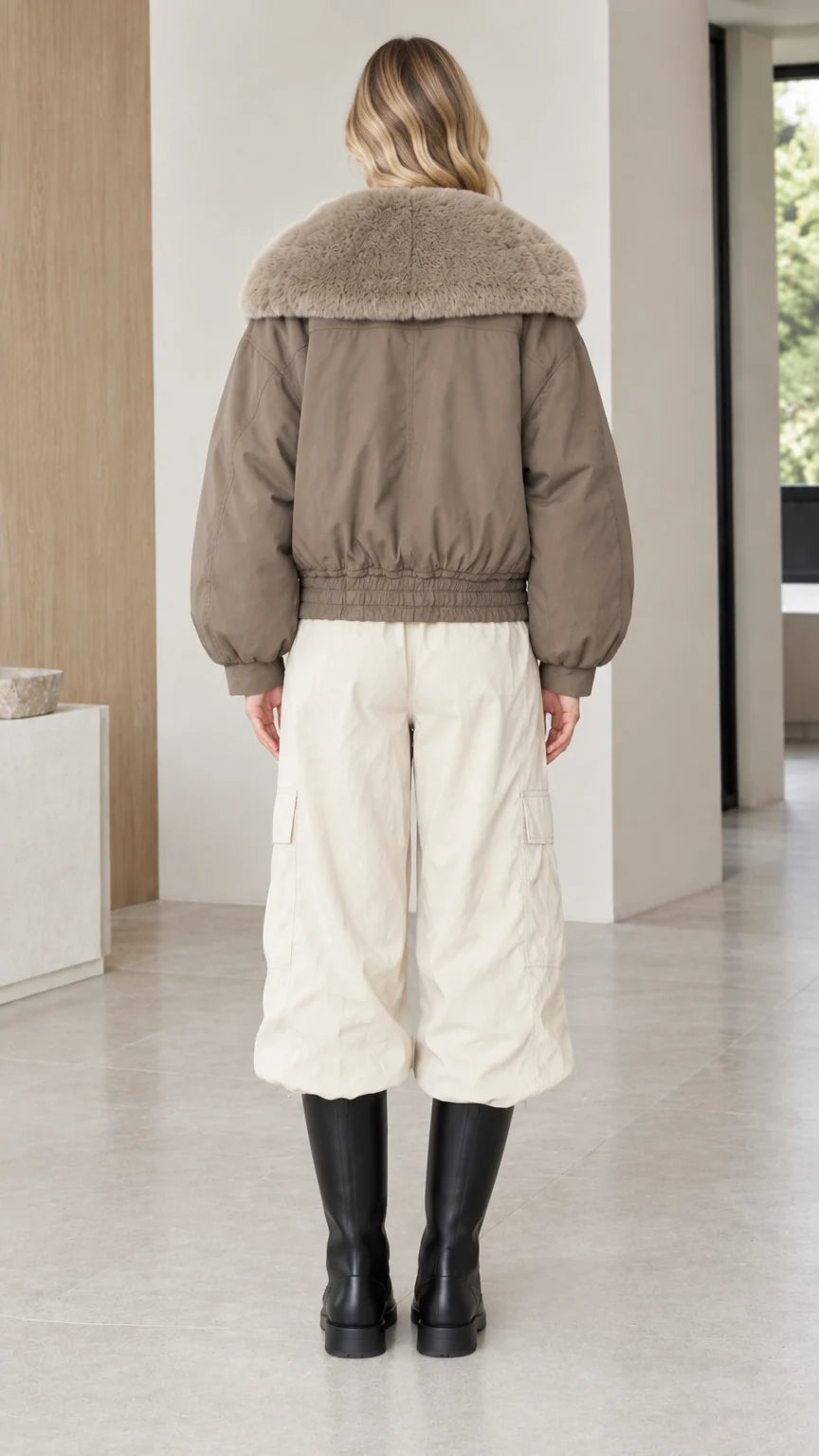 Back view of taupe bomber jacket showing elastic waistband and blouson sleeves