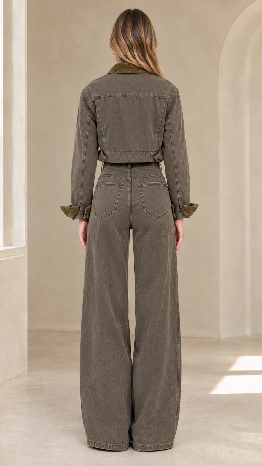 Back view of model in olive green cropped denim jacket and wide-leg trousers