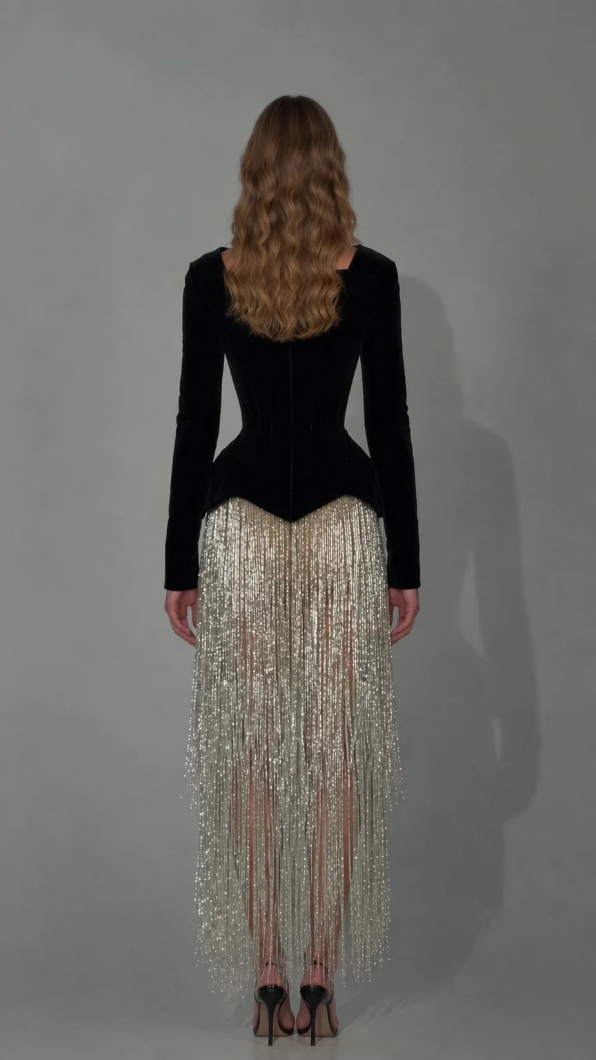 Back view of black velvet corset bodice with fitted long sleeves and fringe skirt