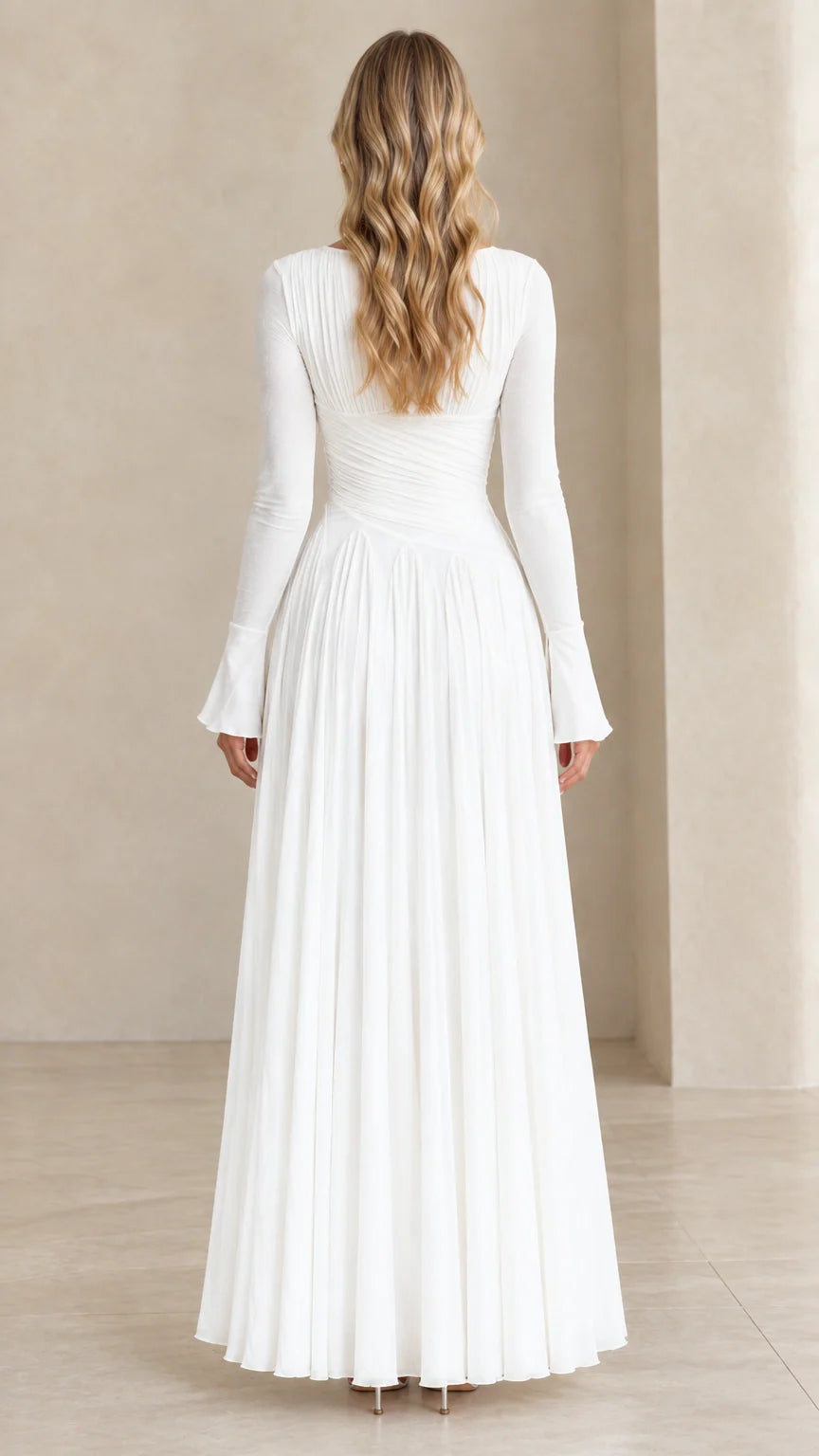 Back view of model wearing white floor-length pleated maxi dress