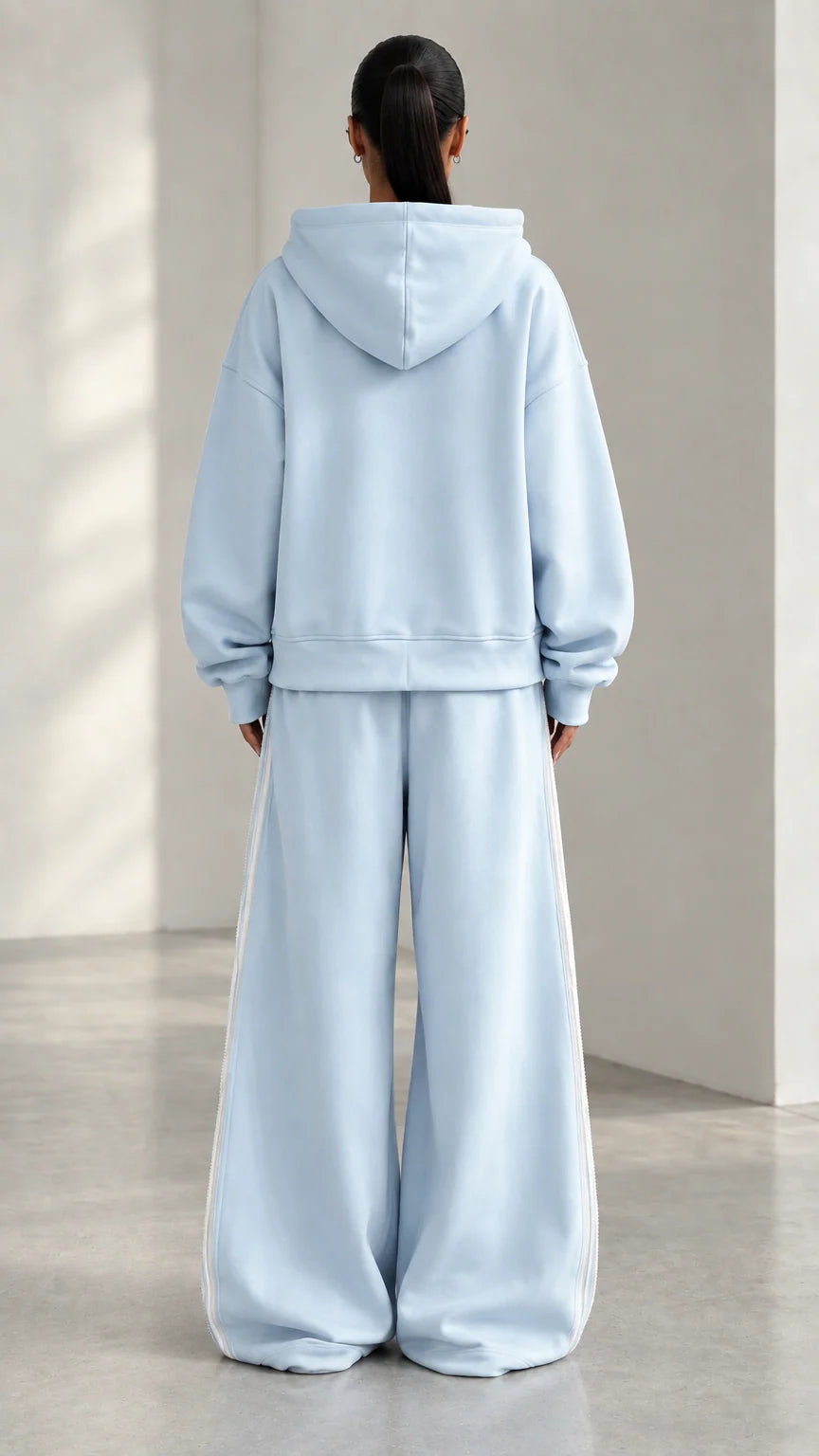 Back view of model wearing Light Blue hooded sweatshirt and matching wide-leg pants
