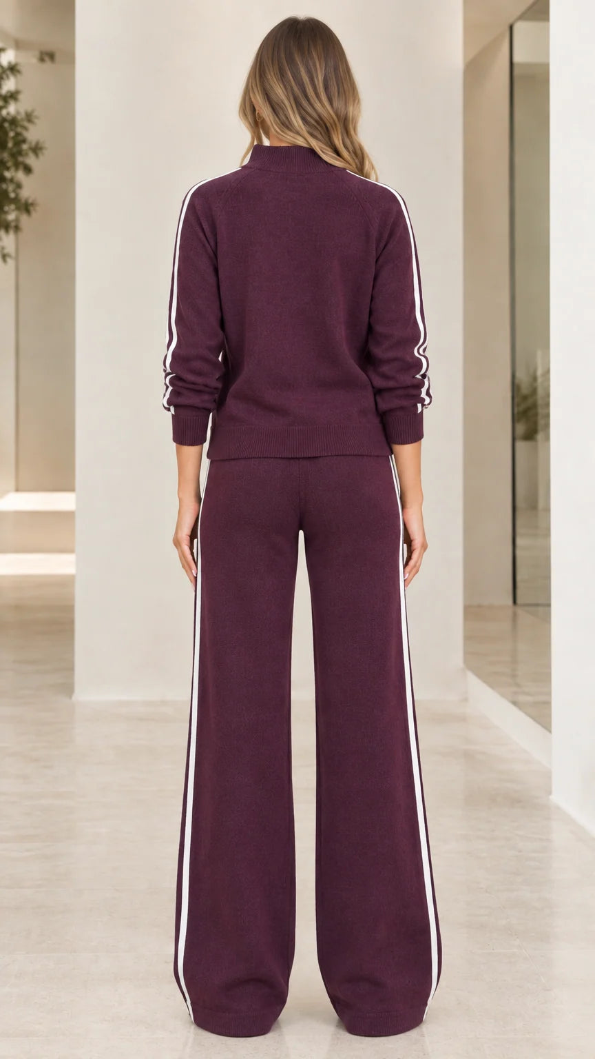 Back view of woman wearing burgundy knit two piece lounge set with side stripes