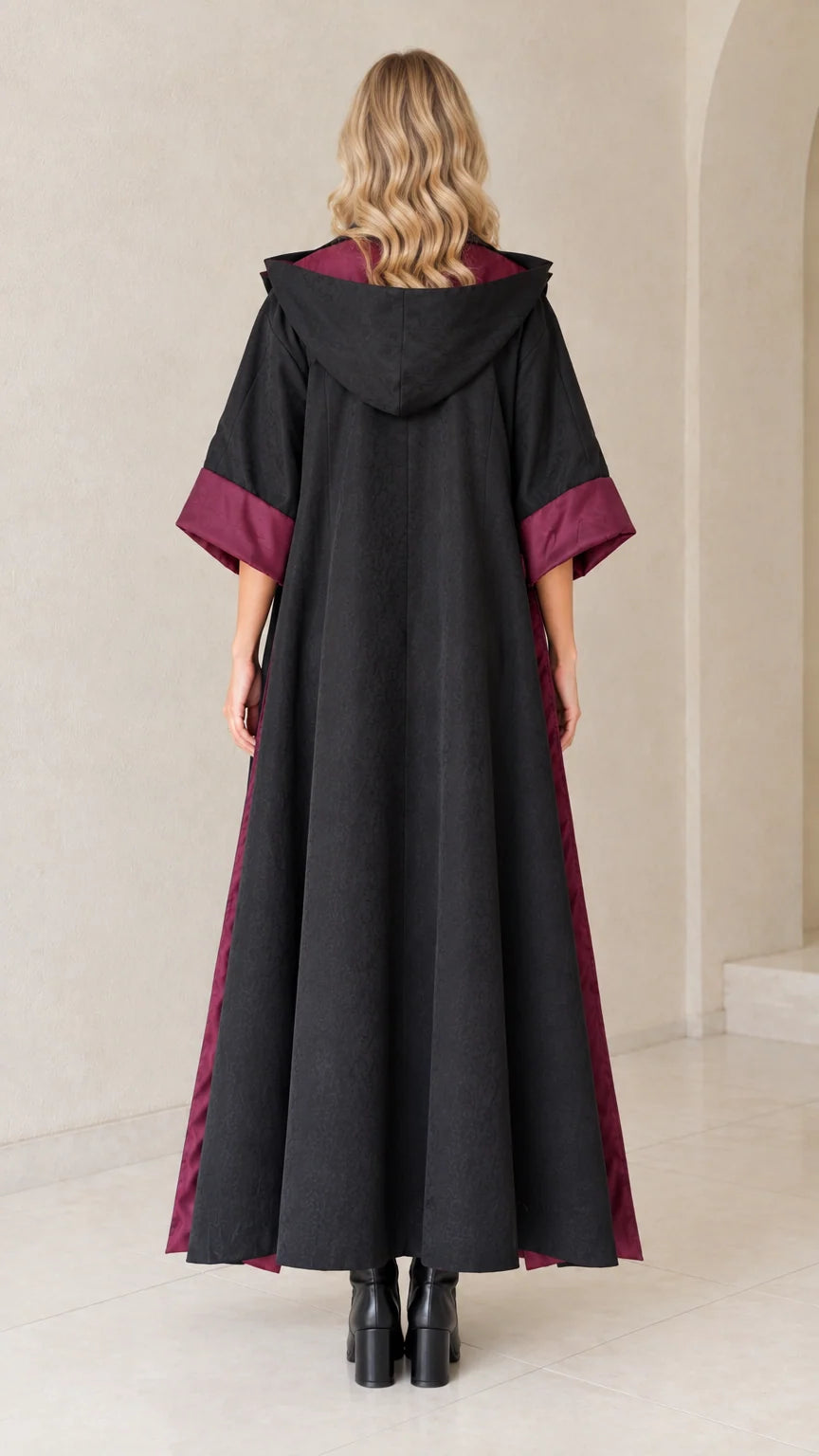 Back view of black hooded duster showing hood drape and ankle-length cut