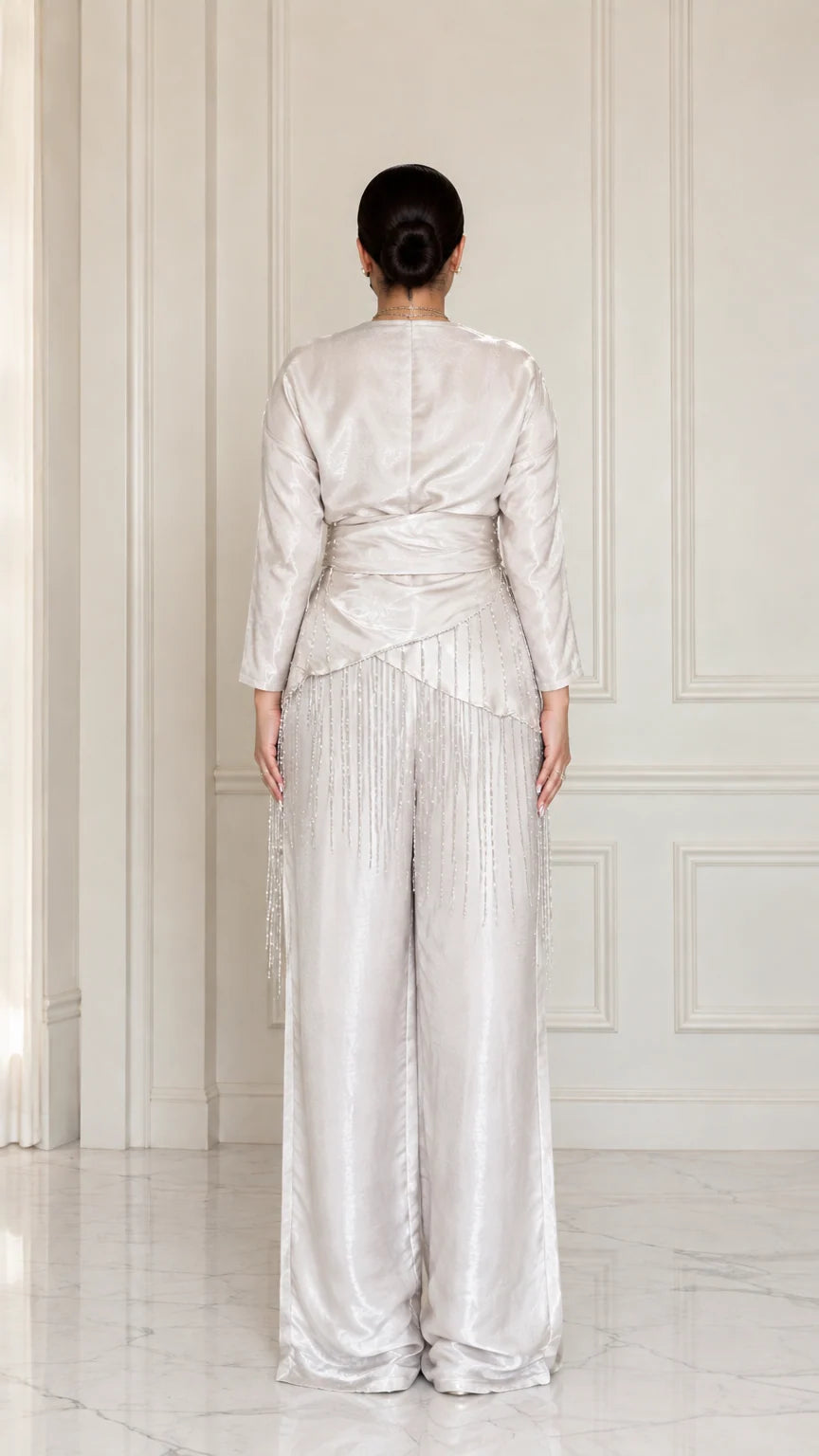 Back full view of model wearing Champagne satin draped blouse and trousers