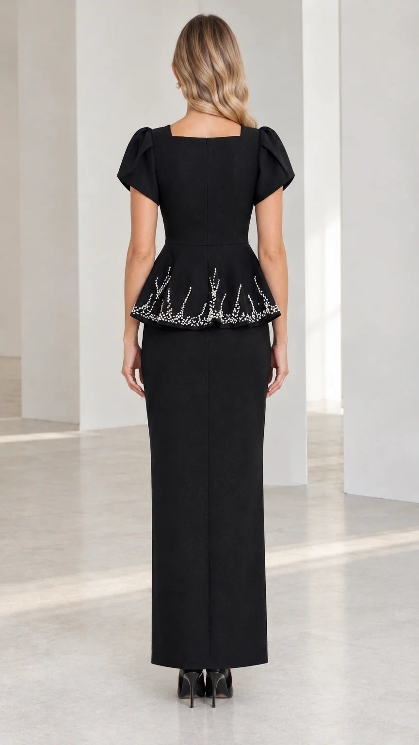 Back view of model wearing black square back peplum maxi dress
