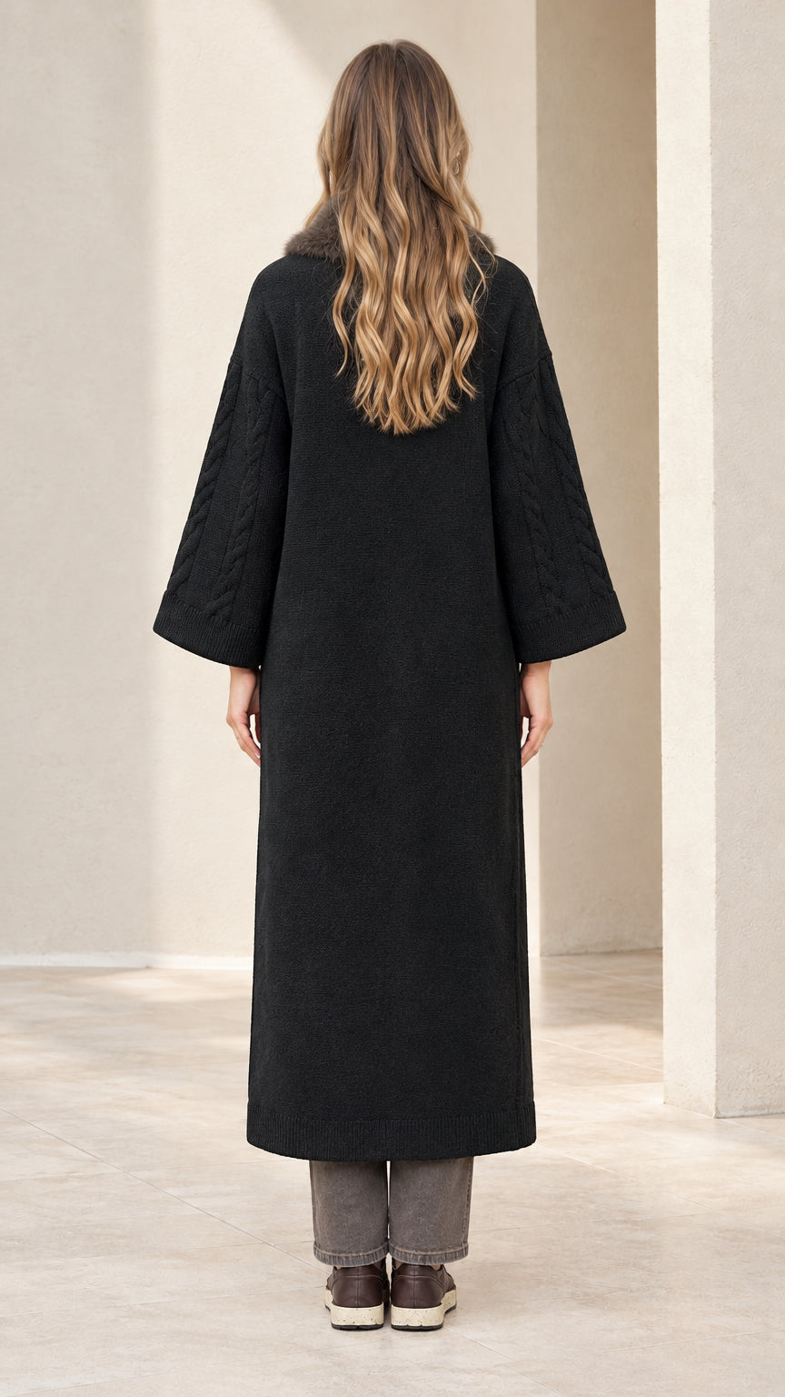 Back view of model wearing black long knit duster coat