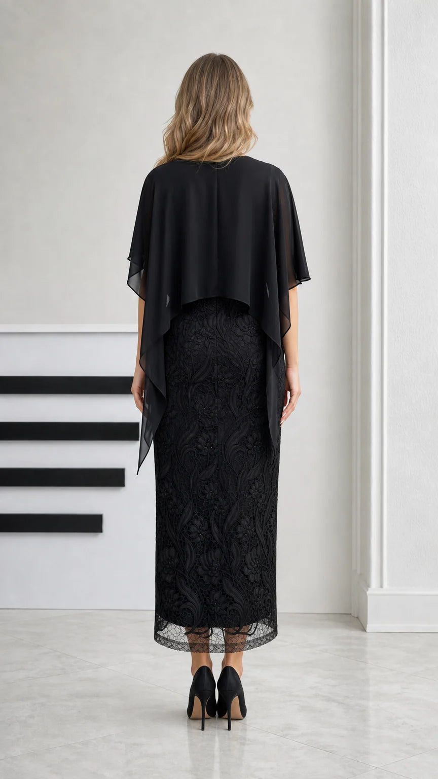 Back view of black midi dress showing chiffon capelet draping