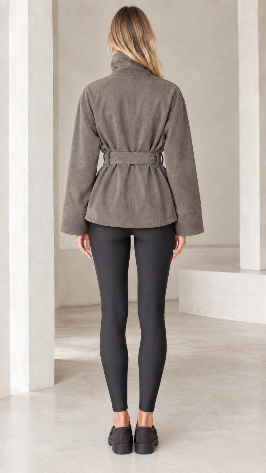 Back view of model wearing taupe belted faux suede jacket with stand collar