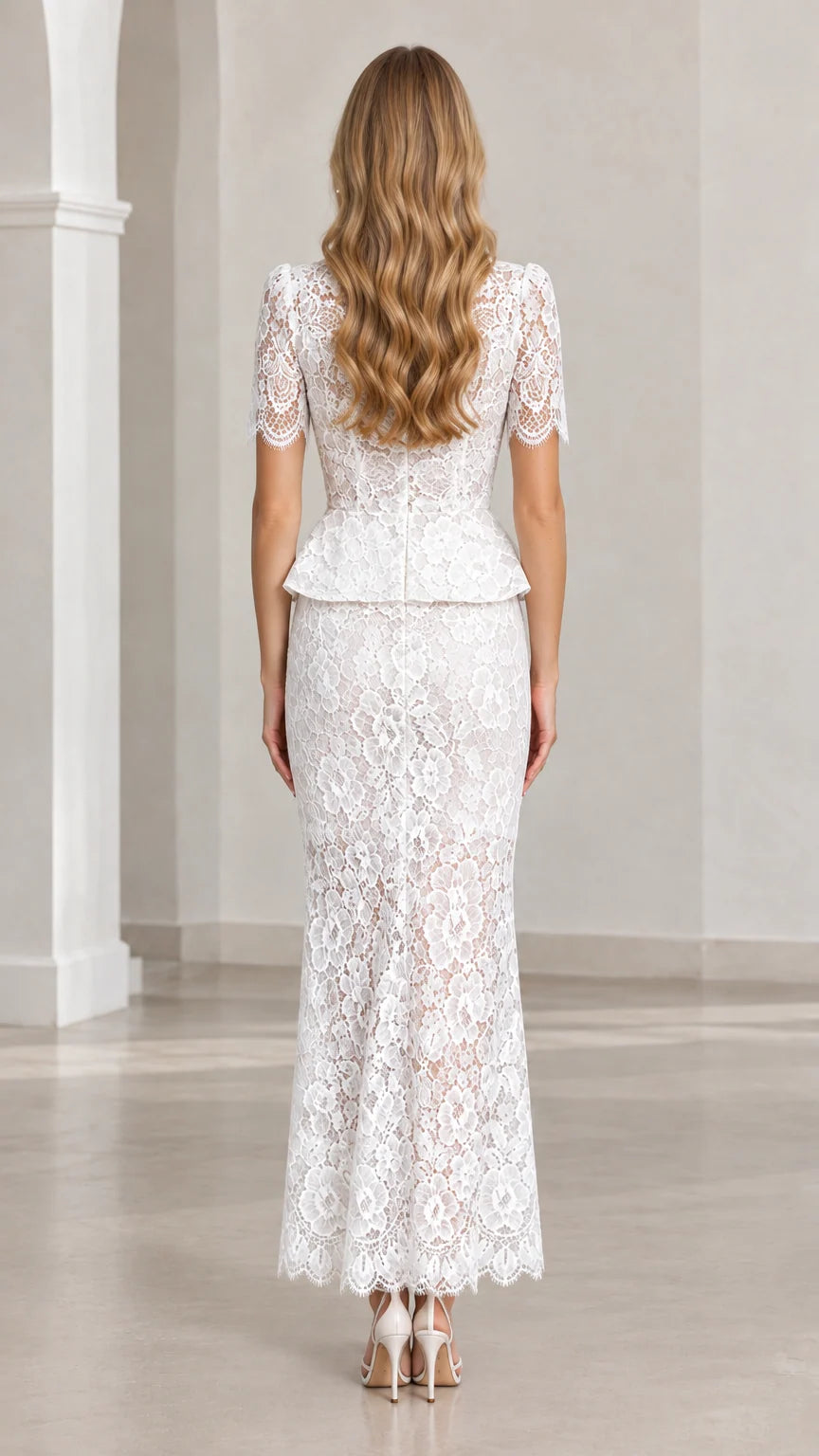 Back view of woman wearing white lace peplum top and column maxi skirt