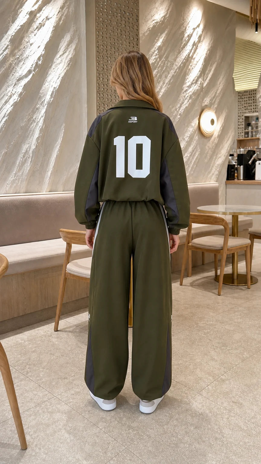 Back view of model in olive green tracksuit jacket showing graphic number 10
