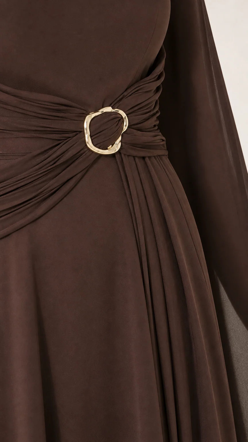 Close-up detail of side waist ruching and gold-tone circular buckle accent