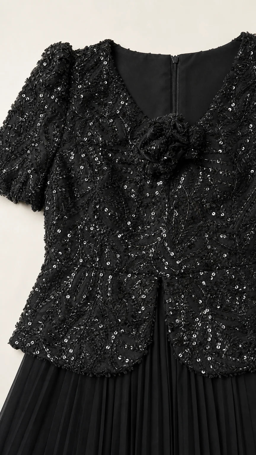 Close-up detail of black sequin bodice with 3D floral rosette and zipper back
