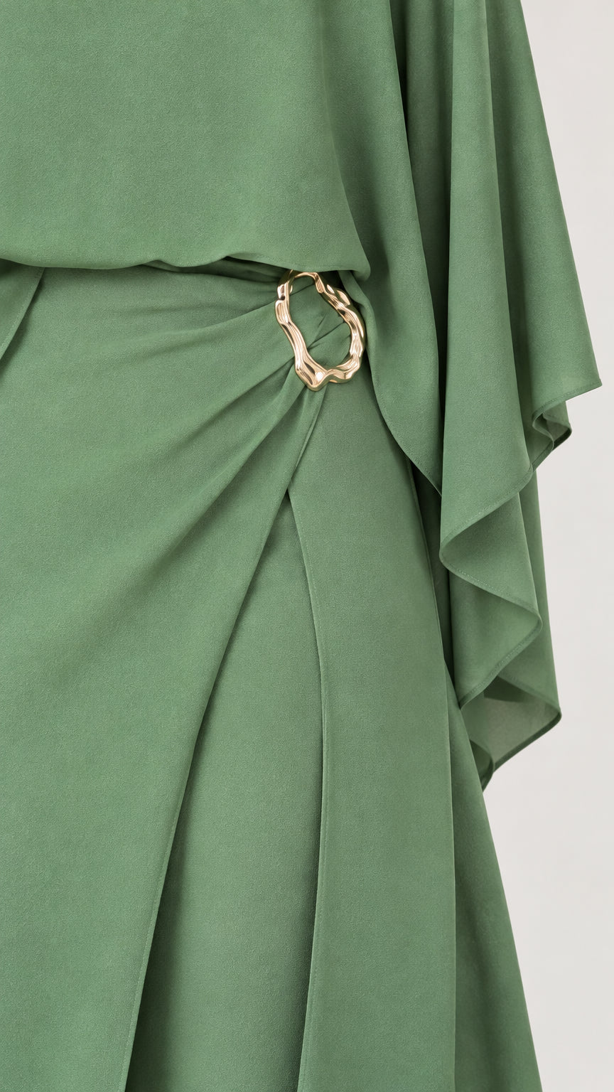 Close-up of sage green jumpsuit draped waist pleats and gold-tone metal buckle