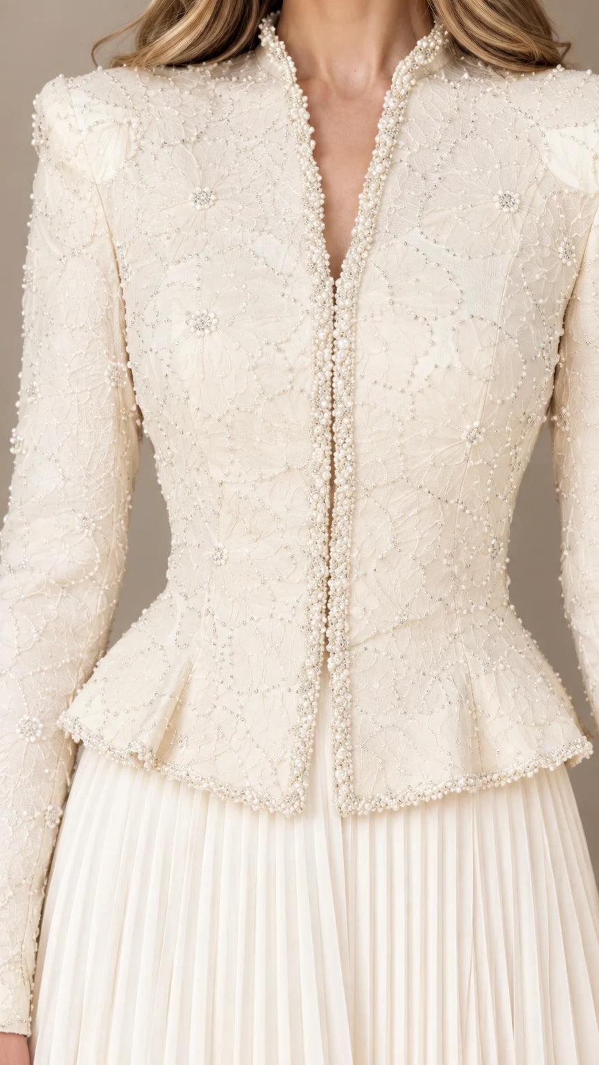 Close-up detail of delicate beadwork, neckline, and peplum hem on jacket