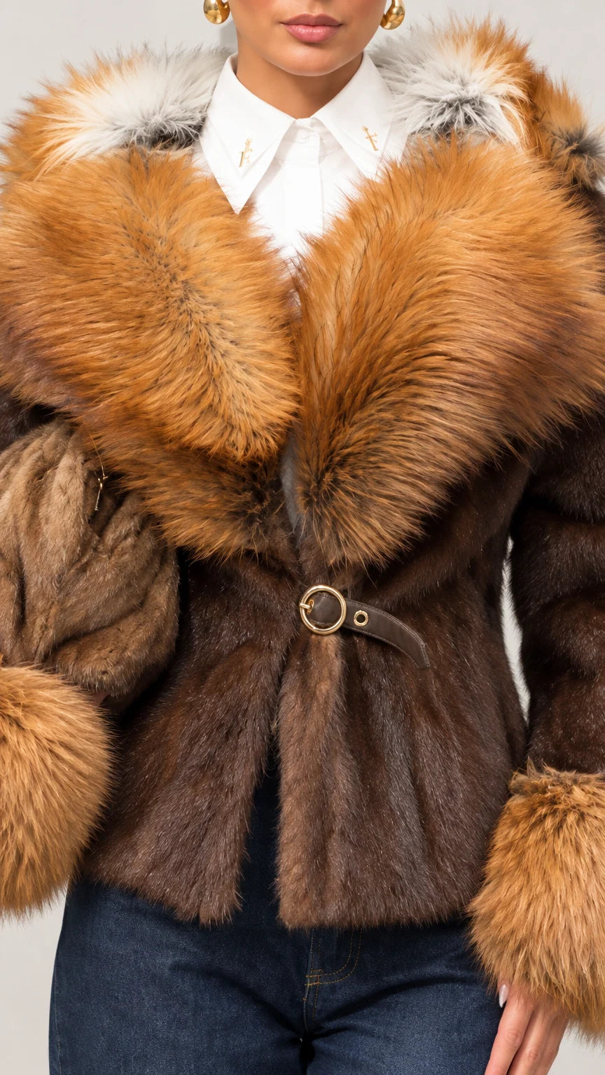 Close-up detail of brown jacket showing ring buckle closure, white collared shirt layer, and plush faux fur collar