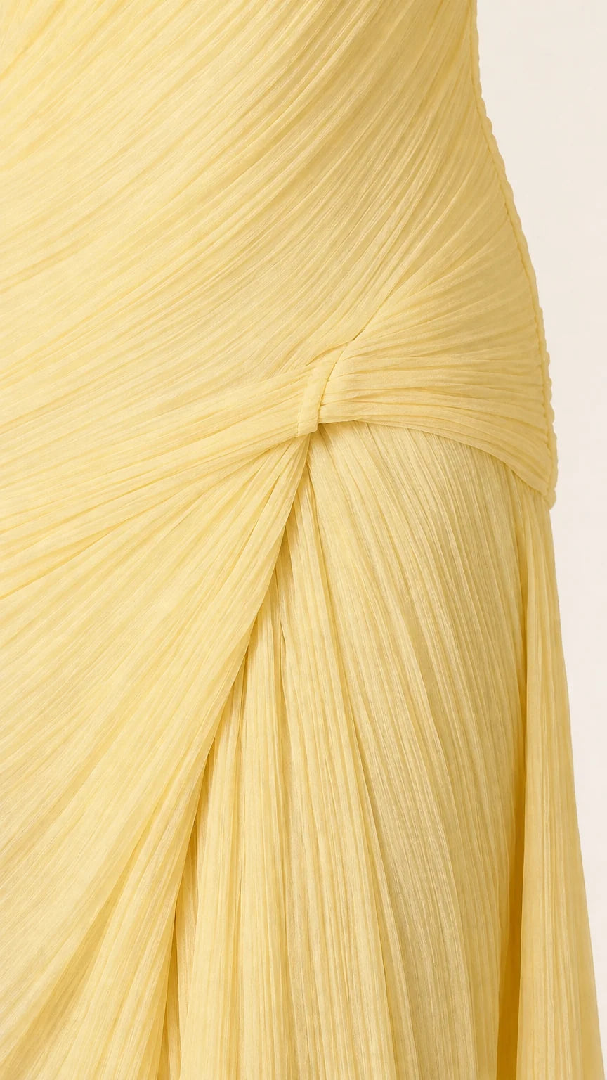 Close-up detail of pleated texture and side knot on yellow maxi dress