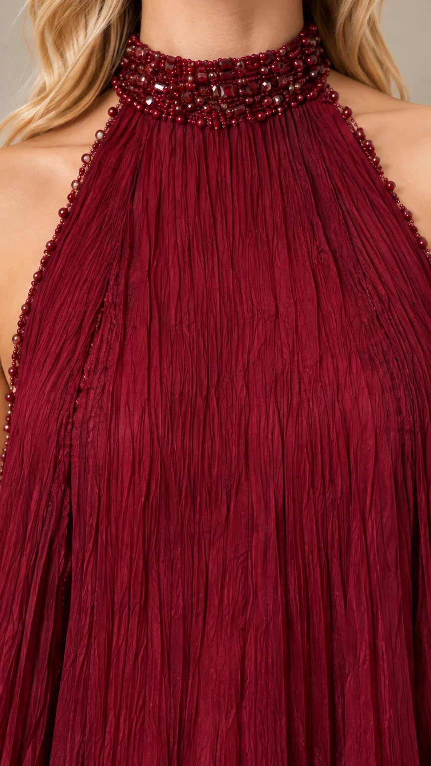 Close-up of beaded halter collar and micro-pleated burgundy fabric