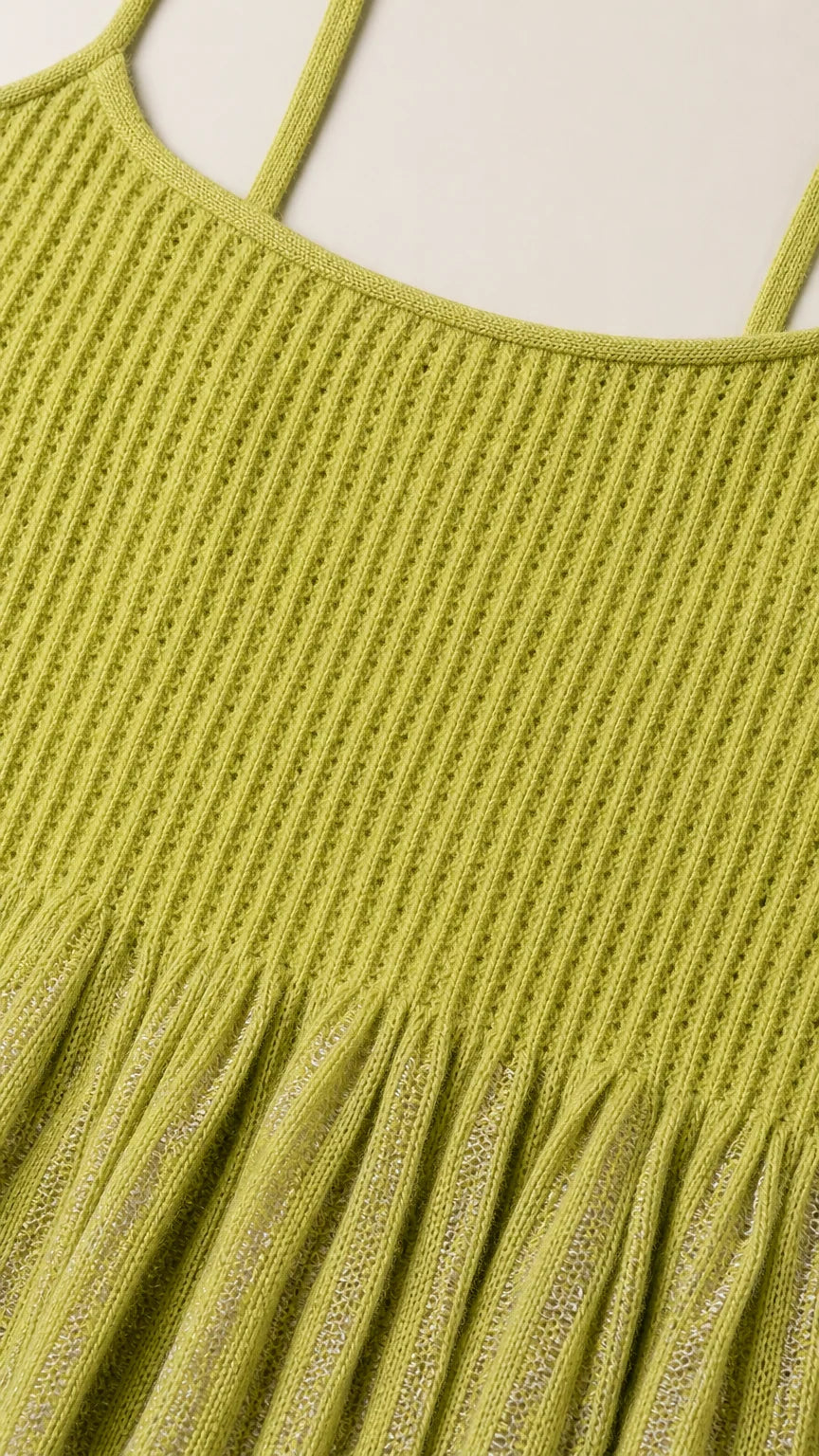 Close-up detail of green knit texture and flounce hem