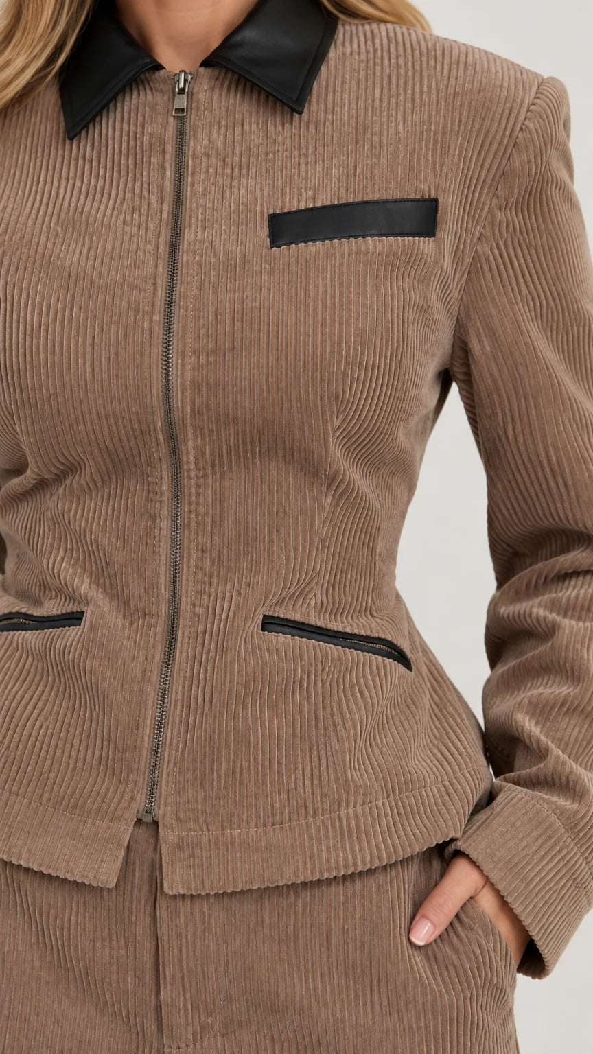 Close-up detail of taupe ribbed corduroy texture, zip closure, and contrast black collar