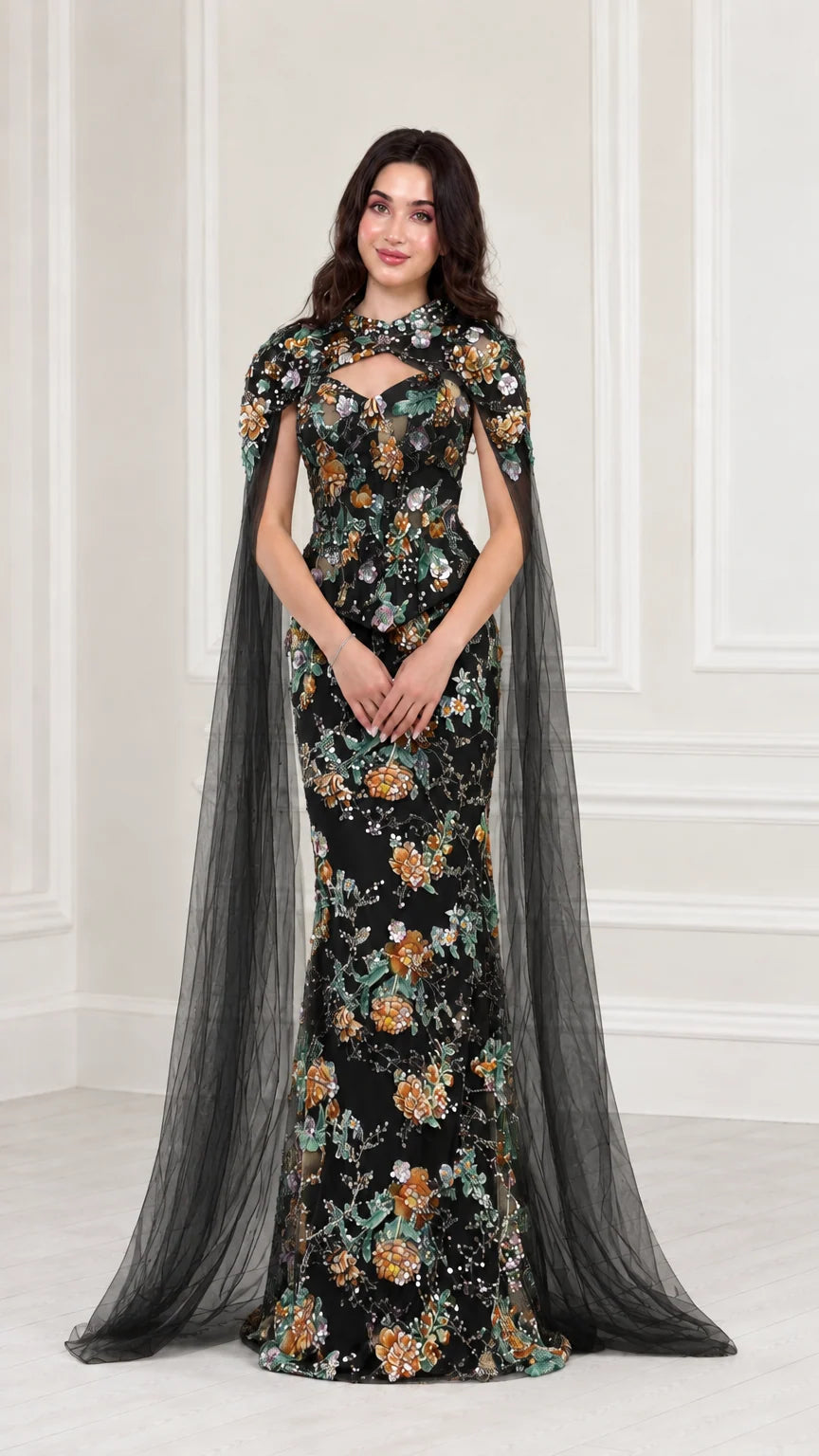 Front view of Black floral embroidered evening gown with sheer black cape