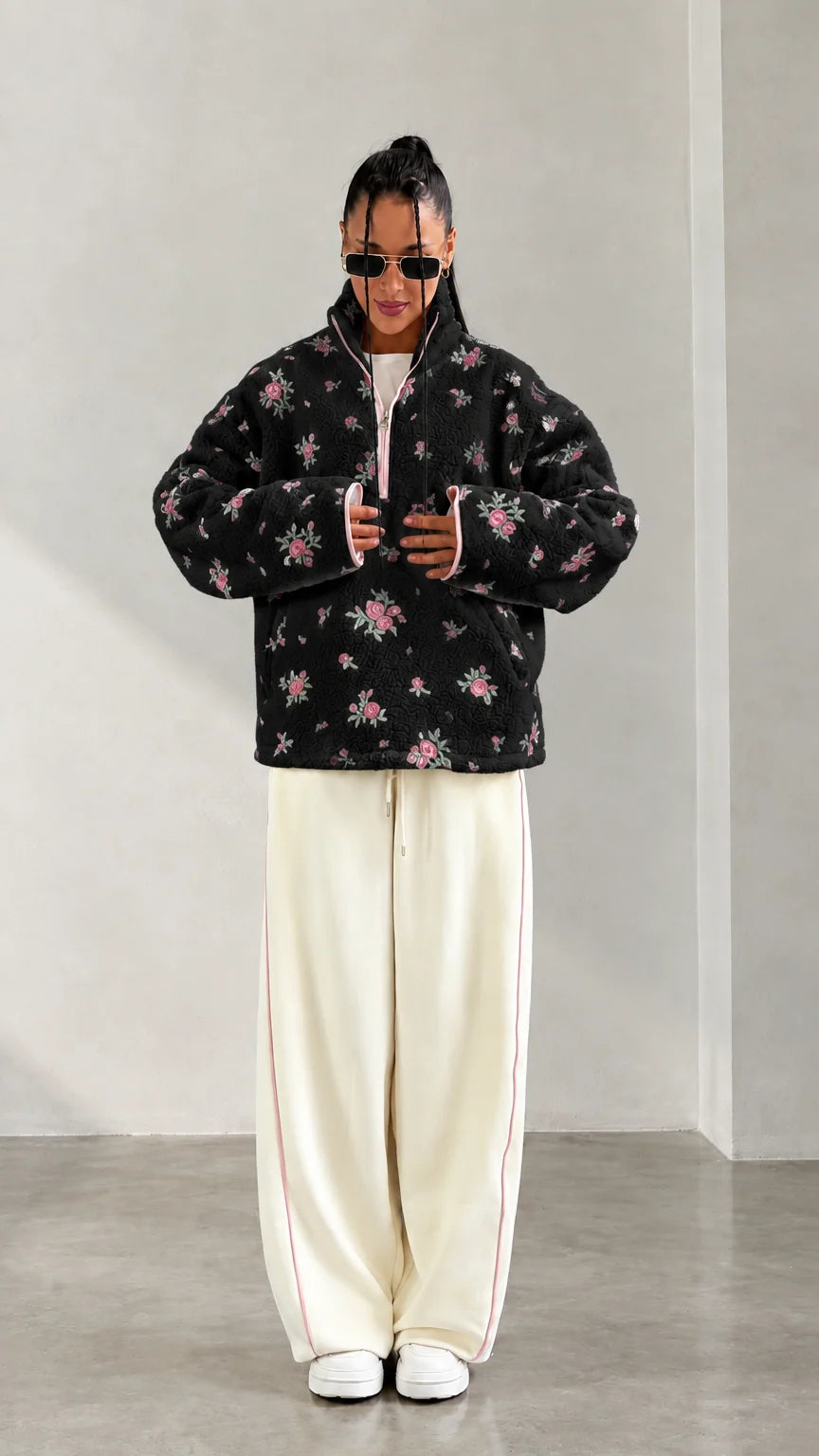 Front view of model wearing black floral print half-zip fleece pullover