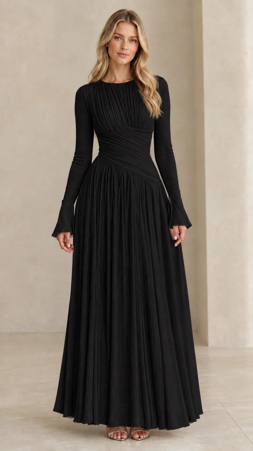 Model wearing black long sleeve pleated maxi evening dress